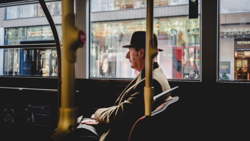 A man sitting on a bus. Photo by abi ismail on Unsplash
